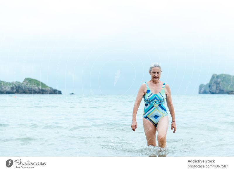 Glückliche ältere Frau beim Baden im Meer Strand Senior MEER Wasser aktiv Badeanzug passen Sommer positiv alt gealtert graues Haar Gesunder Lebensstil genießen