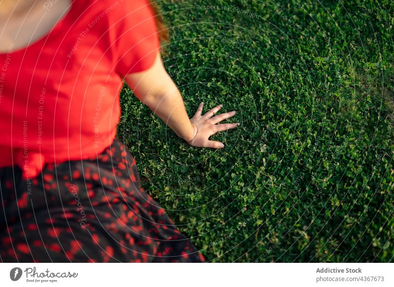 unkenntliche Ernte Frau chillt auf Rasen im Park Sommer Gelassenheit Harmonie Sonnenuntergang friedlich Wiese genießen Gras Natur Feld sitzen Windstille ruhig
