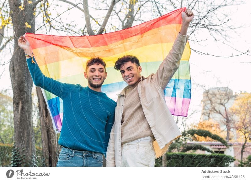 Glückliches schwules Paar mit LGBT-Regenbogenfahne im Park lgbt Fahne Männer Stolz gleich Homosexualität Toleranz männlich Liebe Zusammensein