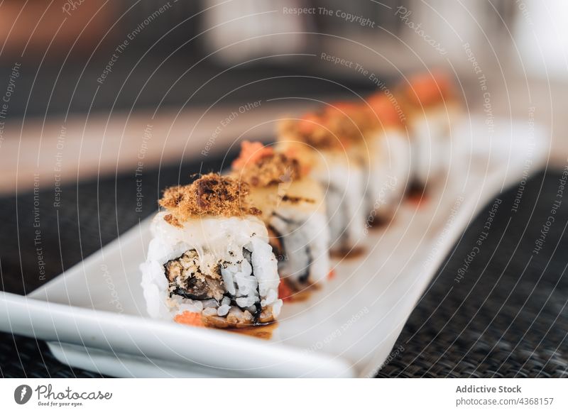 Leckere Sushi-Rollen auf einem Teller im Restaurant rollen Meeresfrüchte Asiatische Küche Reis Mittagessen Mahlzeit Speise lecker Orientalisch Reihe