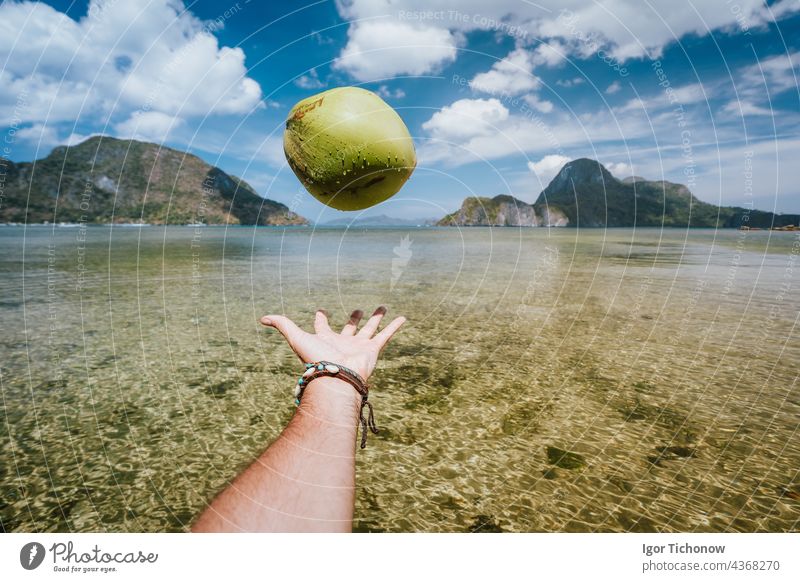POV Jonglieren mit Kokosnuss in männlichen Händen gegen exotische Inseln im Ozean Bucht palawan jonglieren Strand pov Reiseziele Himmel Nido tropisch Hand
