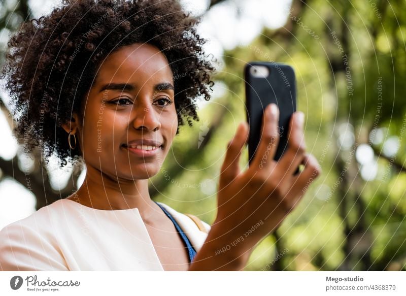 Afro-Geschäftsfrau bei einem Videogespräch auf einem Mobiltelefon. Afro-Look Business Frau Anruf App Zelle Videoanruf sprechend Mitteilung im Freien Software