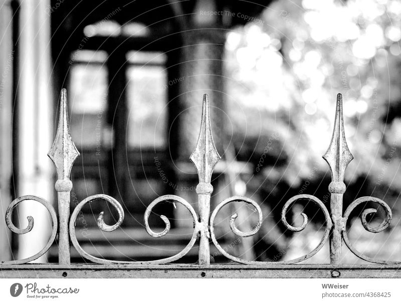 Ein verwunschenes, vielleicht längst verlassenes Haus hinter einem kunstvoll geschmiedeten Zaun Ornament geschwungen schmiedeeisern Hinderniss Villa alt