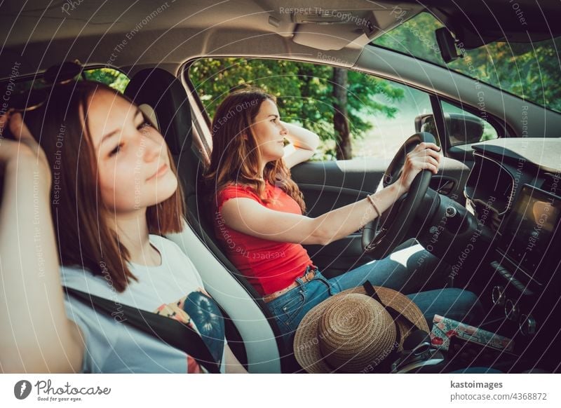 Zwei junge Mädchen fahren im Auto und genießen den Sommerausflug in der Natur. Ausflug Straße PKW Zusammensein reisen Frau Urlaub Freunde Abenteuer Glück