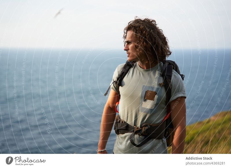 Reisender Mann, der auf einem Hügel gegen das Meer läuft reisen Spaziergang Backpacker Feld Sommer Trekking Freiheit männlich Wiese MEER Wanderung Rucksack
