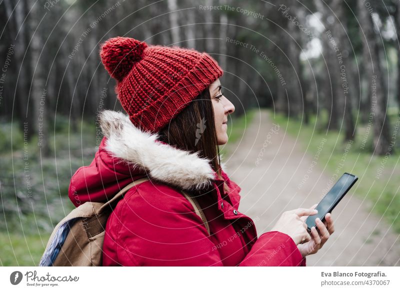 Nahaufnahme von Backpacker kaukasische Frau zu Fuß im Wald mit Handy im Winter oder Herbst Saison. Lebensstil und Natur. Weitwinkelansicht Technik & Technologie