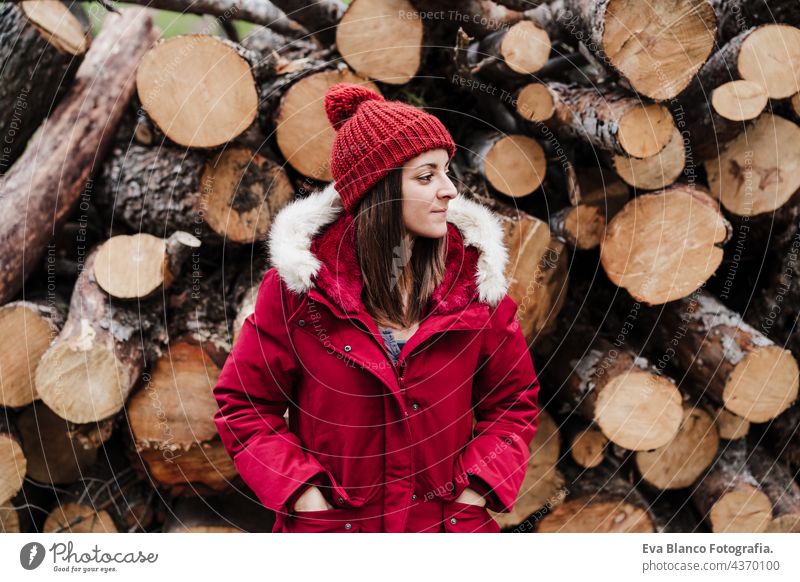 entspannte kaukasische Frau steht vor auf Holzstämme in Berg im Herbst oder Winter Saison. Lebensstil und Natur Wald kalt Ausflug Berge u. Gebirge rot Hut
