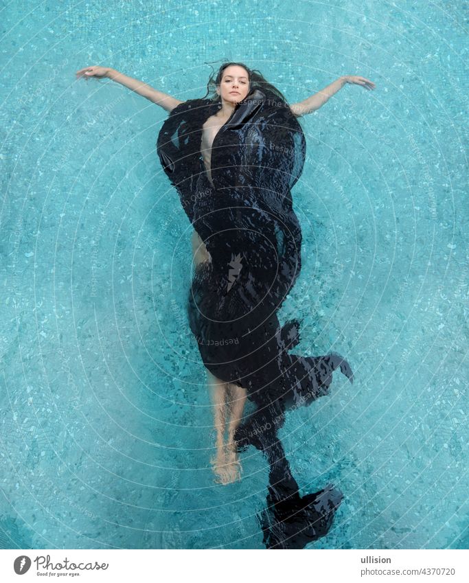 schöne junge Frau in schwarzem Kleid, elegantes Schwimmen im Pool dunkelbraune lockige Haare Fächerform im Wasser Feiertag Baden Sommer MEER blau Spaß Glück