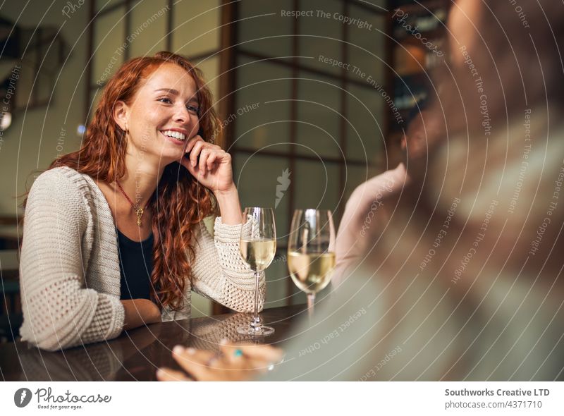 Junge Frau entspannt sich mit Freunden in einer Bar jung Erholung trinken Gastfreundschaft Lächeln Glück Rotschopf im Innenbereich Tag Veranstaltungsort zwei