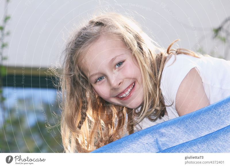 Porträt eines fröhlich, lachenden 8jährigen Mädchens mit langen, blonden Haaren beim Spielen auf der Rutsche Kind 1 Kindheit Mensch 8-13 Jahre Sommer langhaarig