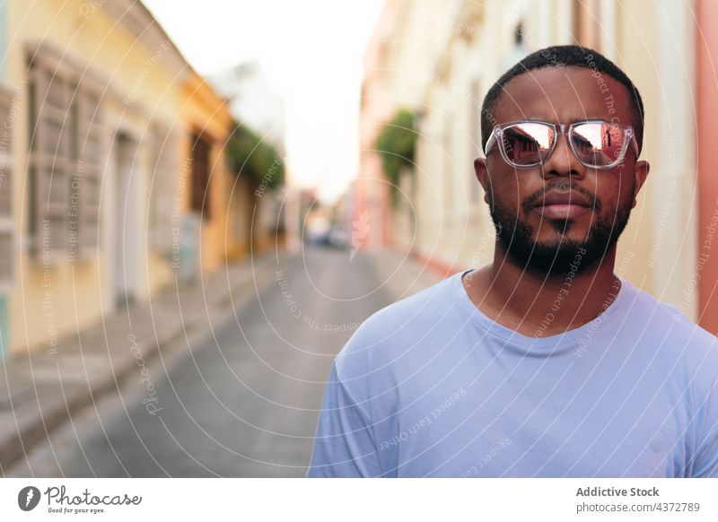 Porträt eines stilvollen afroamerikanischen Mannes mit Sonnenbrille im Freien. Modischer schwarzer Mann auf der Straße. selbstbewusst männlich Erwachsener