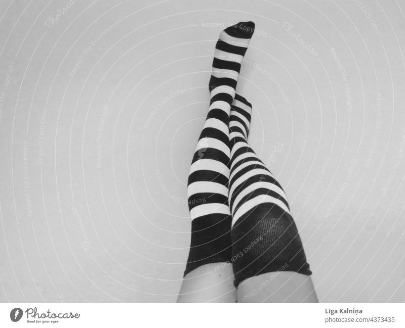 Beine in gestreiften Socken in Schwarz und Weiß Fuß stehen Strümpfe Ringelsocken Mensch schwarz auf weiß Schwarzweißfoto Körperteil Schuhe Kniestrümpfe
