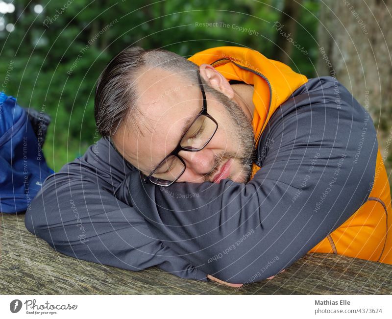 Mann mit Brille schläft und ruht sich aus ausruhen liegen schlafen Erholung Sommer Ferien & Urlaub & Reisen erledigt daypack Rucksack Tasche ausschlafen reisen