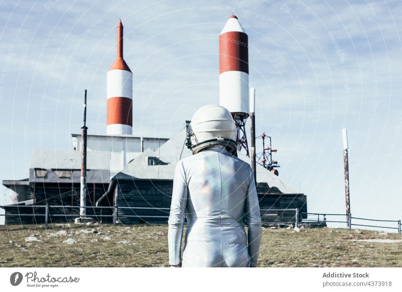 Kosmonaut gegen raketenförmige Antennen Mann Astronaut Rakete Weltraumbahnhof Konzept erkunden Zukunft Innovation Missionsstation männlich Zaun behüten