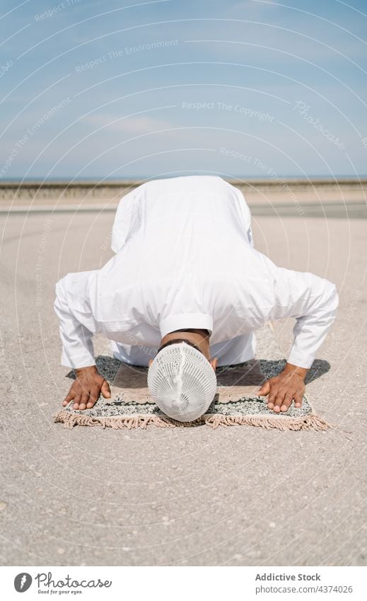 Islamischer Mann betet auf Matte am Strand muslimisch arabisch beten Religion knien Schleife Tradition Kultur Vorleger Ritual Anbetung heilig männlich ethnisch