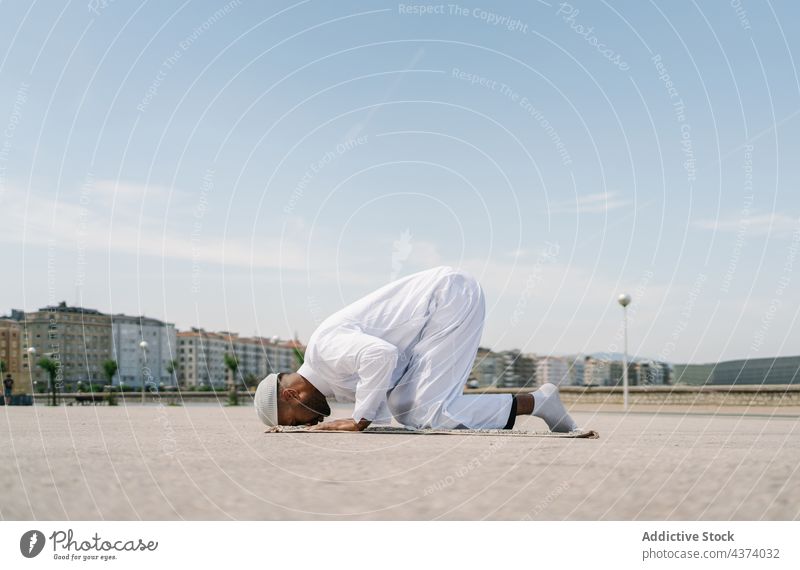 Islamischer Mann betet auf Matte am Strand muslimisch arabisch beten Religion knien Schleife Tradition Kultur Vorleger Ritual Anbetung heilig männlich ethnisch