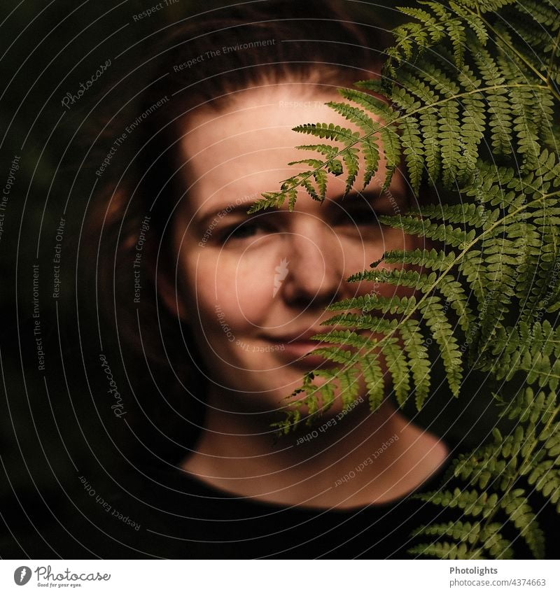 Junge Frau versteckt sich hinter einem Farnblatt Porträt Schatten Licht Tag Außenaufnahme Farbfoto Mensch 1 Gesicht Erwachsene 18-30 Jahre feminin