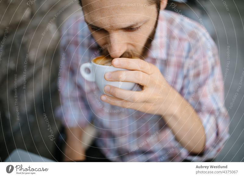 Junger Mann trinkt Kaffee in einem Café im Freien 25-30 30-35 Jahre Erwachsener Amerikaner Vollbart bärtig Blogger Chef brünett Geschäftsinhaber Kalifornien