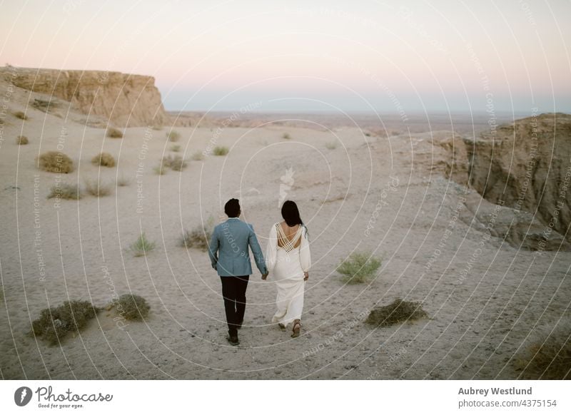 Paar, das im Sand durch eine Wüste läuft anza-borrego-wüste asiatisch Ödland Kakteen Kaktus Kuscheln kostümiert Emotion Erosion Abend Schriftarten Punkt