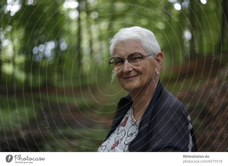 Portrait - Seniorin lächelt im Wald Porträt Frau Großmutter Weiblicher Senior 60 und älter weißhaarig grauhaarig natürlich authentisch Brille Natur alt