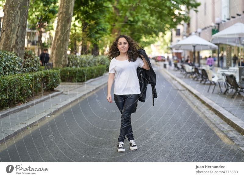 junge Frau in schwarzem Leder und weißem T-Shirt mitten auf der Straße gekleidet hispanisch angekleidet Mitte Lebensalter 20s Freiheit Glück Fröhlichkeit Dame