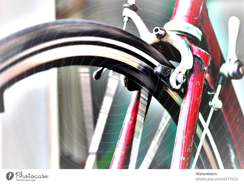 Drehendes Vorderrad eines Rennrads mit rotem Rahmen Fahrrad schmaler Reifen schwarz Fahrradrahmen Felge drehend in Fahrt Bremse Bremsbacken Bremshebel