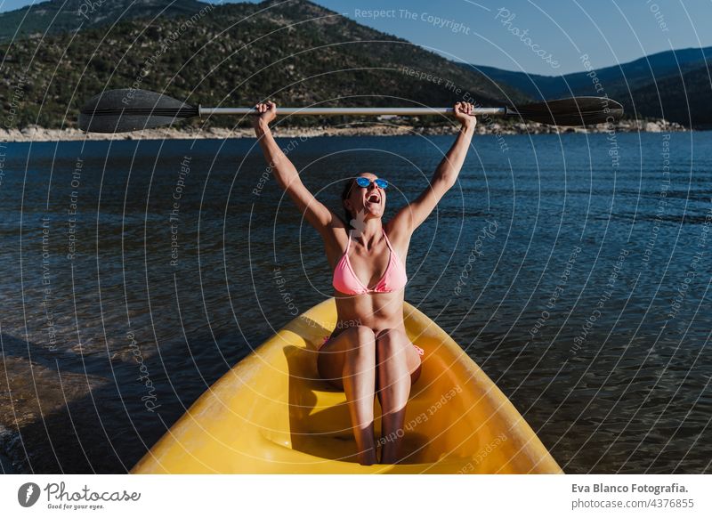 glückliche kaukasische Frau hält Ruder sitzen auf gelben Kanu in See während sonnigen Tag. Sommerzeit. Sport, Abenteuer und Natur Rudern Glück Kaukasier