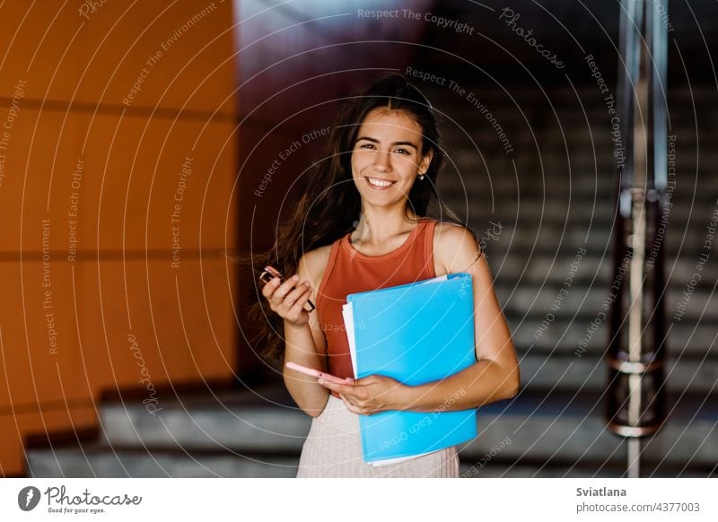 Porträt einer Studentin mit Aufsatz in einer Mappe, Telefon und Brille in der Hand, die zur Vorlesung eilt Mädchen Schüler Treppe Frau jung lässig Smartphone