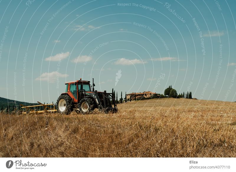Traktor auf einem Feld in der Toskana Landwirtschaft Natur Ackerbau Italien landwirtschaftlich Bauernhof ländlich Landschaft blauer Himmel