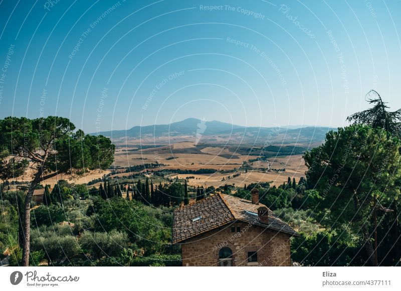 Haus in toskanischer Landschaft mit Hügeln und Zypressen Toskana Italien warm Sommer grün Bäume Natur blauer Himmel mediterran