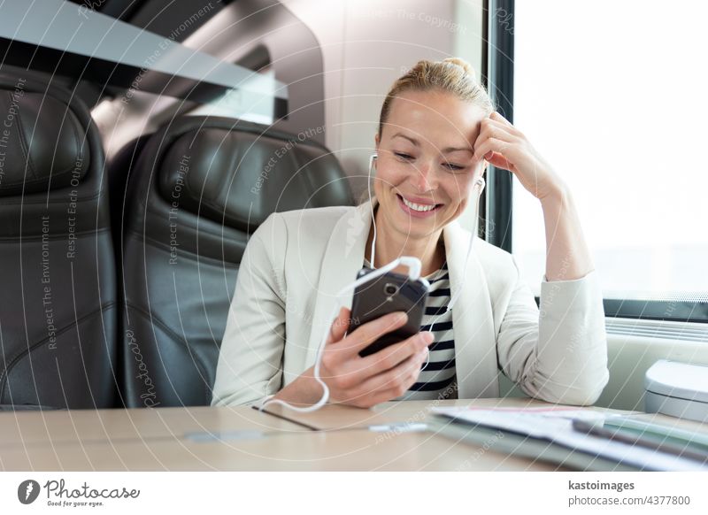 Geschäftsfrau, die während einer Zugfahrt mit ihrem Mobiltelefon kommuniziert. reisen Business Mobile Telefon modern Person professionell Sitzen klug Mitteilung
