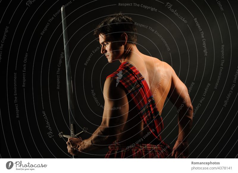 Der sexy Highlander posiert für das Foto. Krieger Prinz König episch Held Kilt Kostüme Schwert Waffen mittelalterlich Wikinger Vampir Lust Burg oder Schloss
