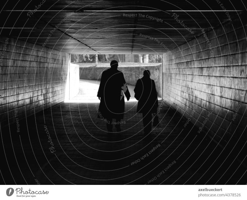 Silhouetten eines Paares, das durch Fußgängertunnel geht Schatten unkenntlich Unterführung Tunnel dunkel Architektur gehen Wege & Pfade Licht Gegenlicht
