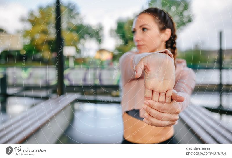 Junge Sportlerin streckt Hände und Handgelenke im Freien strecken Finger Aufwärmen Athlet Frau Textfreiraum Vordergrundorientierung Training Fitness jung