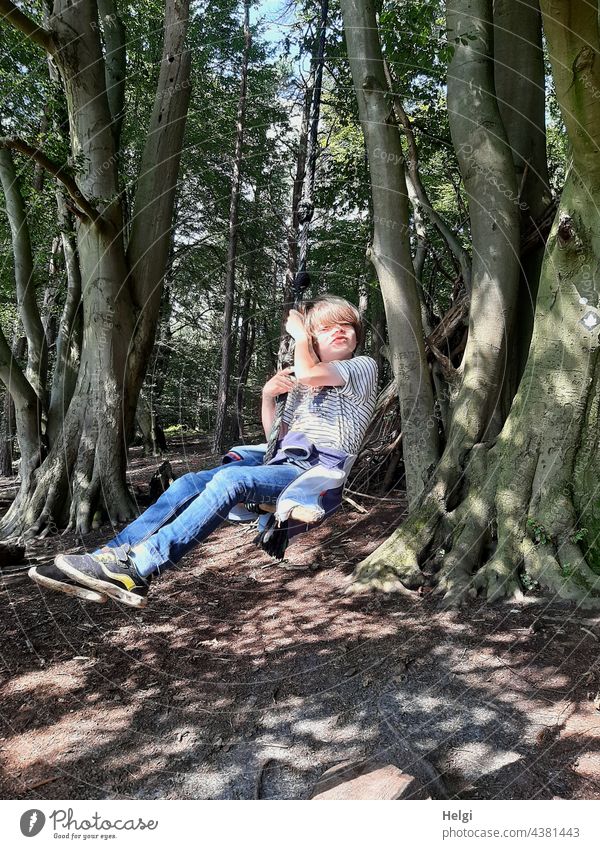 Kind schaukelt im Wald auf einer Baumschaukel Mensch Schulkind Schaukel schaukeln Buchenwald Freude Spaß Vergnügen Licht Schatten Sonnenlicht Sommer Natur