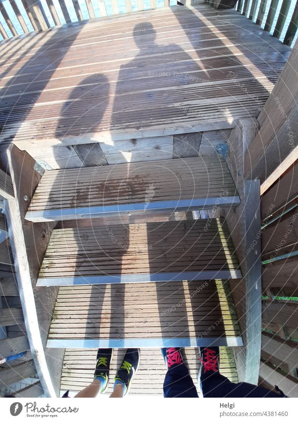 stufenweise - unterbrochene Schatten einer Erwachsenen und eines Kindes auf den Holzstufen einer Aussichtsplattform Stufen Füße Schuhe Turnschuhe Licht