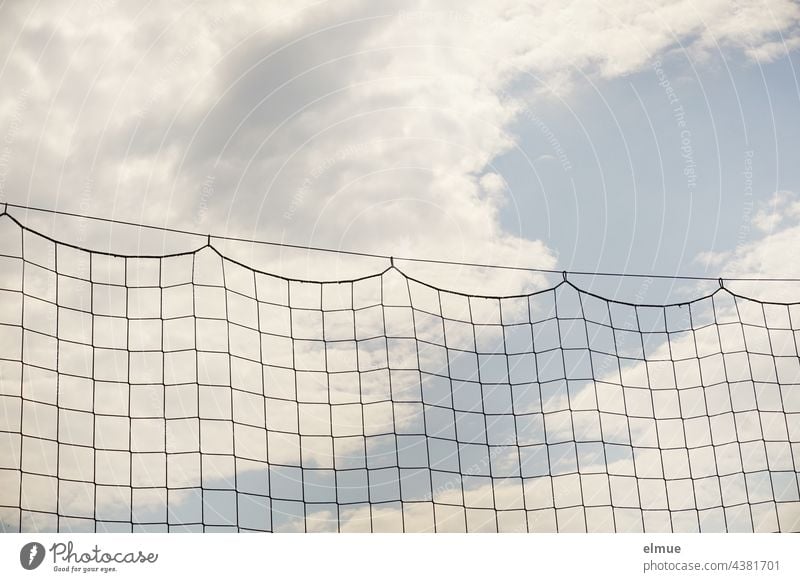 Ballfangnetz an einem Stahlseil vor hellblauem Himmel mit Wolken / abhängen / Fußball / Netzwerk Schutznetz Sicherheitsnetz Ballsport Ballsportarten Abgrenzung