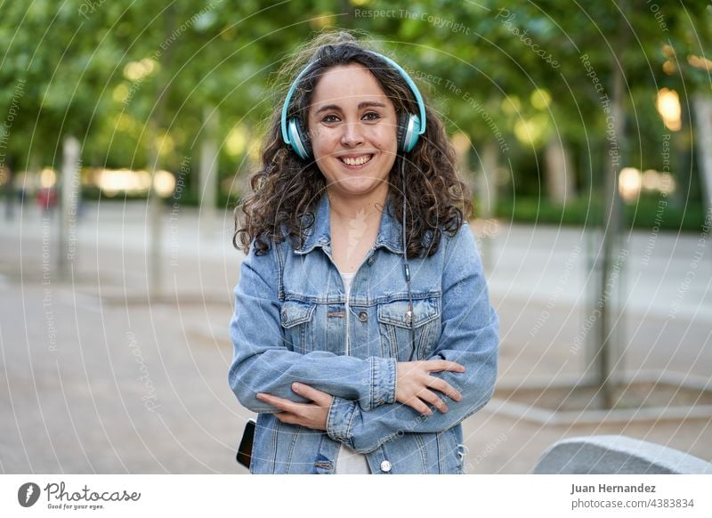 Frau hört Musik über Kopfhörer, die mit ihrem Smartphone verbunden sind jung hört zu Handy Mobile Telefon klug Funktelefon Zelle Headset hören zuhören benutzend