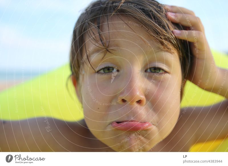 Kind schaut verwirrt in die Kamera und verzieht das Gesicht Blick in die Kamera Oberkörper Porträt Textfreiraum rechts Textfreiraum links Coolness selbstbewußt