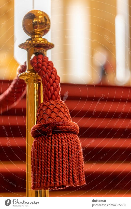 Edle rote Quaste hängt an goldener Absperrung Troddel Oper Geländer edel Nahaufnahme hängen Detailaufnahme Dekoration & Verzierung Treppe abspettung Handlauf