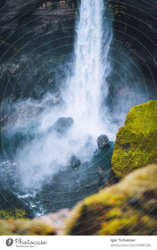 Nahaufnahme des Haifoss-Wasserfalls in Südisland. Das Wasser prallt gegen die Felsen am Boden und spritzt herum. Unscharfer Vordergrund Island Gesäß Steine