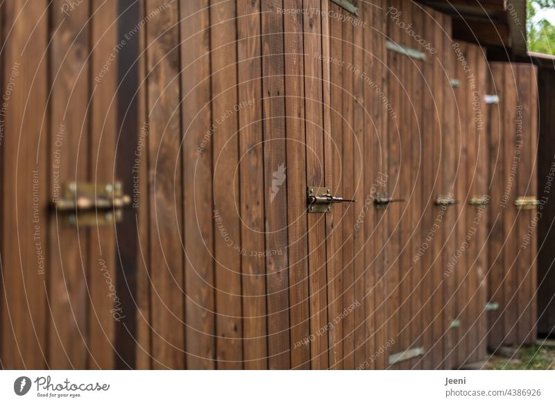 Viele Umkleidekabinen Umkleiden Holz Holztür See Badewiese Badestelle Badeanstalt hintereinander nebeneinander gleichmäßig braun offen Tür Eingang