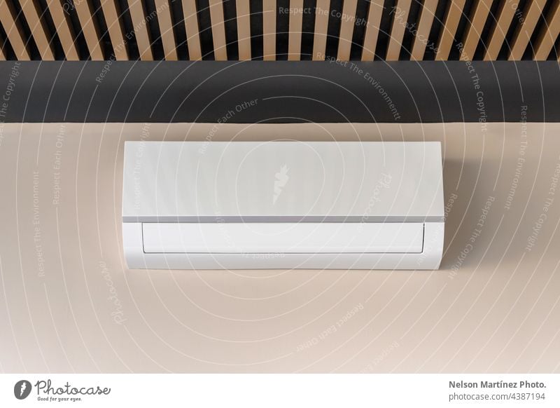 Weißes Klimagerät auf beiger Wand Kühler cool kalt kühlen erwärmen belüftet Temperatur Ventilator Wind Industrie Gerät vereinzelt elektronisch wandmontiert