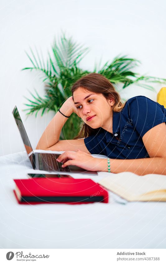 Glückliche Frau arbeitet zu Hause am Laptop benutzend abgelegen digital online freiberuflich Arbeit Bett liegend jung Schüler Kommunizieren Tippen Browsen