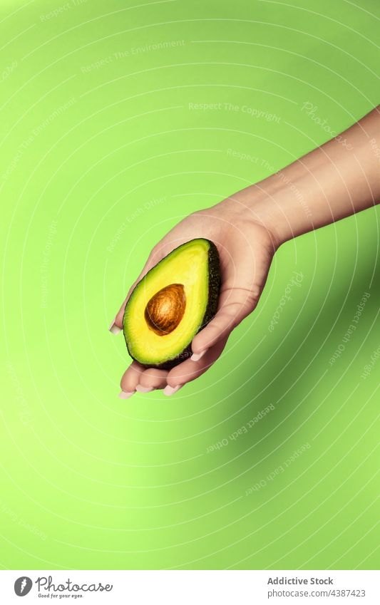 Crop-Frau zeigt frische Avocadohälfte mit Kern Frucht Vitamin gesunde Ernährung tropisch natürlich Samen Hälfte exotisch weich geschnitten Zellstoff lecker