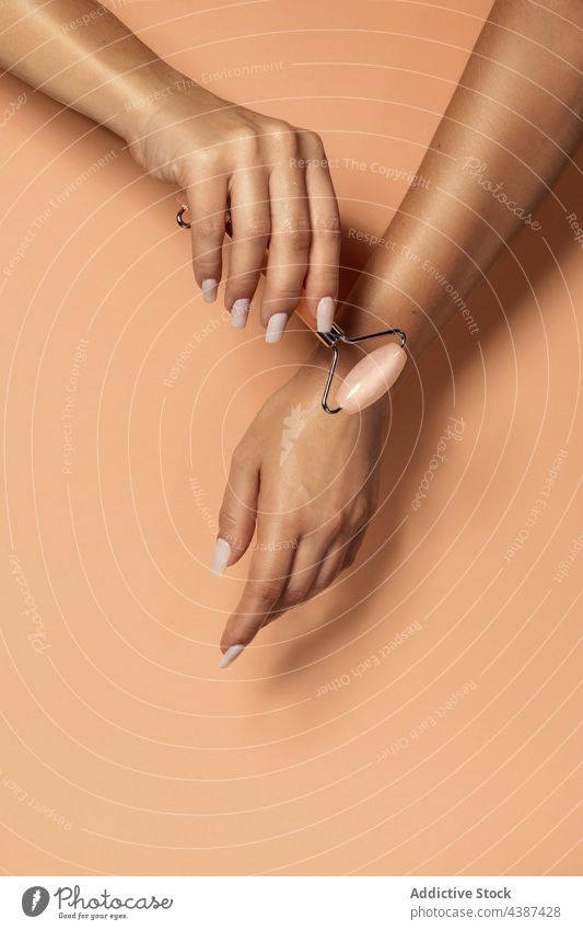 Frau mit Quarzgesichtsroller Rolle Hautpflege Gesichtsbehandlung Hand Schönheit Leckerbissen Massage Spa Kosmetologie Therapie Werkzeug Stein rosa alternativ