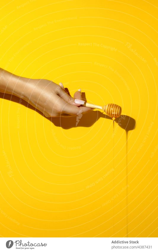 Crop-Frau zeigt Schöpfkelle mit köstlichem Honigfluss Liebling Abblendschalter fließen süß natürlich Leckerbissen organisch lecker farbenfroh Schatten frisch