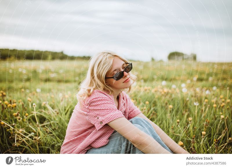 Ruhige stilvolle Frau im Sommerfeld Stil Feld trendy Sonnenbrille ruhig Gelassenheit Wiese Mode charmant verträumt Windstille Natur Blume friedlich Rasen