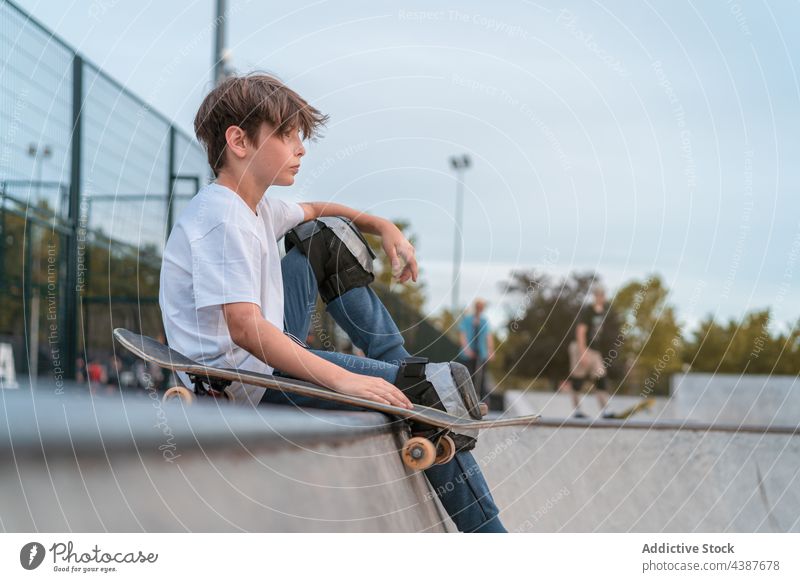 Skateboarder sitzt auf einer Rampe im Skatepark Junge Skater Teenager Skateplatz urban Hipster ernst Hobby Aktivität cool Individualität Erholung Fokus