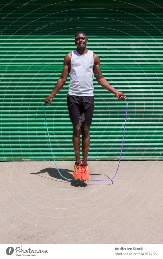 Schwarzer fitter Sportler, der beim Training Seil springt schwarz Hüpfseil springen überspringen Herz Übung Athlet Großstadt männlich ethnisch Afroamerikaner